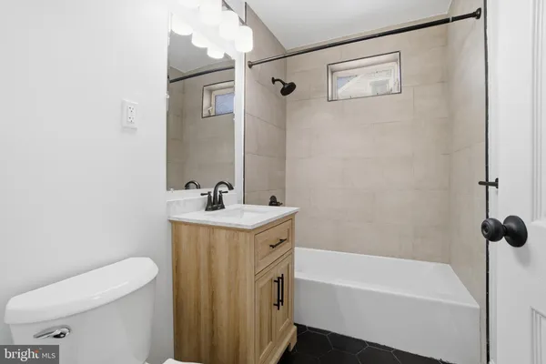 a bathroom with a granite countertop sink a toilet and shower