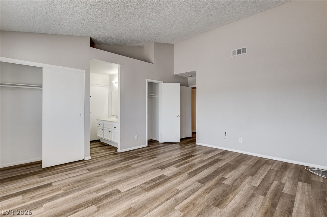 6209 Warm River Road Las Vegas, NV 89108 - Photo 28 of 39 A well-lit bedroom features durable laminate flooring and direct access to a private bathroom.