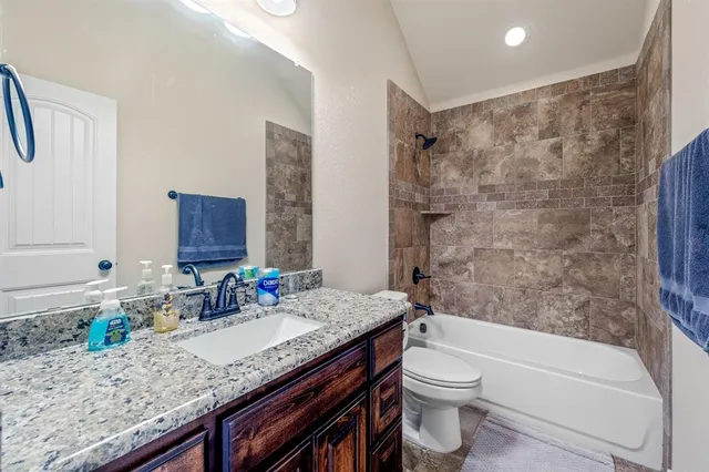 a bathroom with a granite countertop sink toilet and shower
