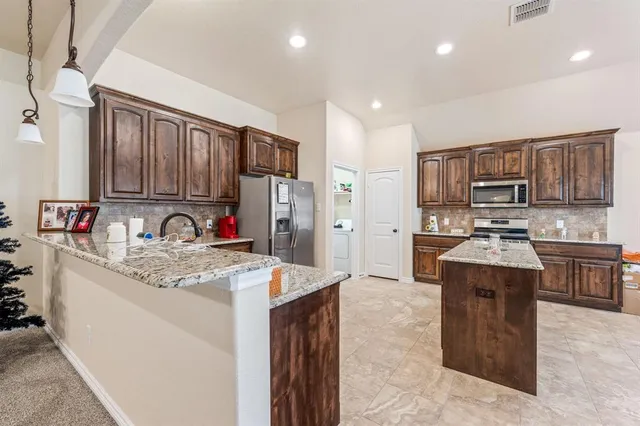 a kitchen with stainless steel appliances granite countertop a sink stove and refrigerator