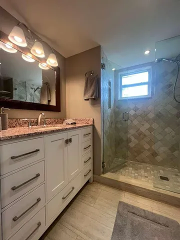 a bathroom with a sink a mirror and a shower