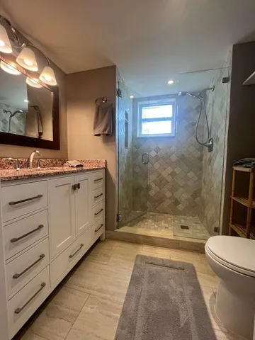 a bathroom with a sink a toilet and shower