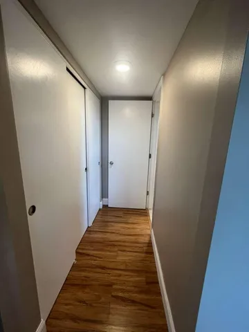 a view of a hallway with wooden floor