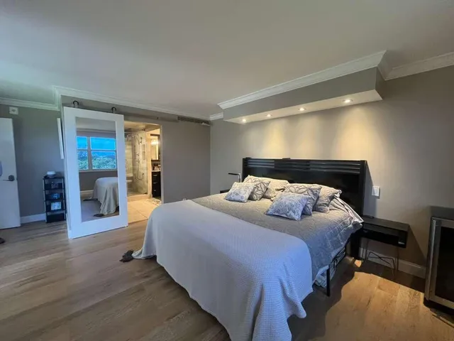 a bedroom with a bed and a large mirror