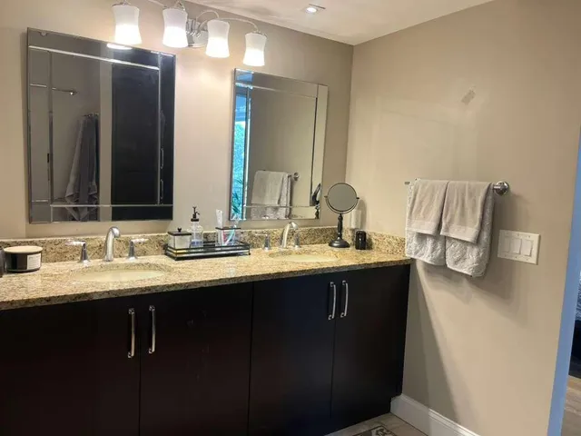 a bathroom with double sink and a mirror