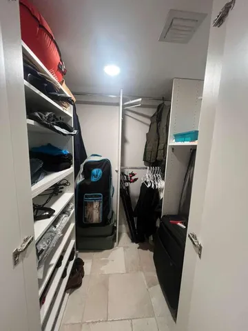 a view of walk in closet with clothes and shoes