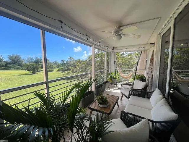 a living room with patio furniture and a floor to ceiling window