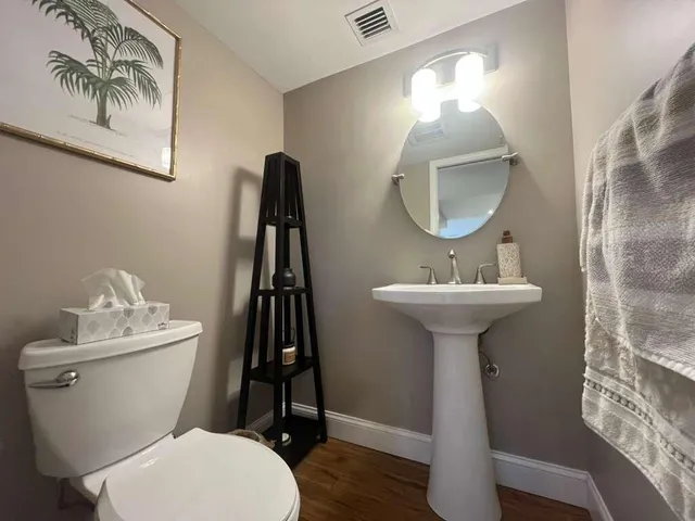 a bathroom with a toilet sink and mirror