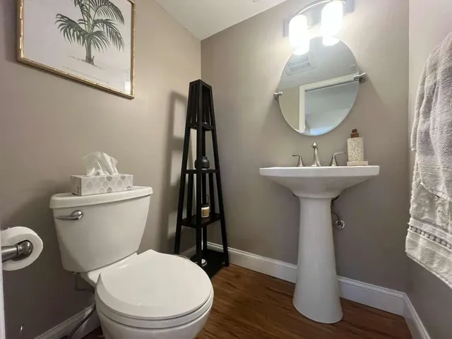 a bathroom with a sink a mirror a toilet and a mirror