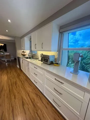 a kitchen with granite countertop white cabinets and white appliances