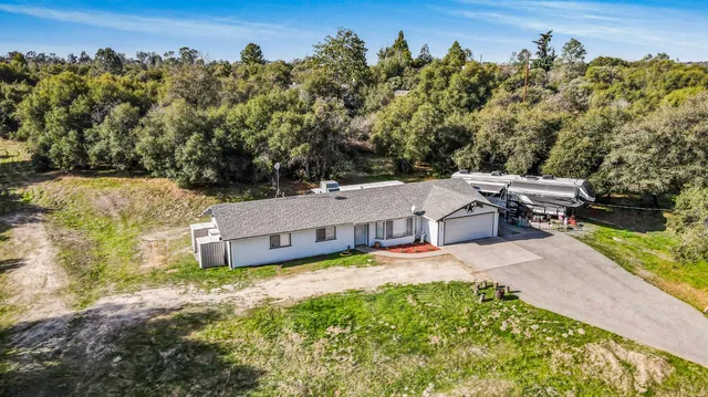 an aerial view of a house with a yard swimming pool and outdoor seating