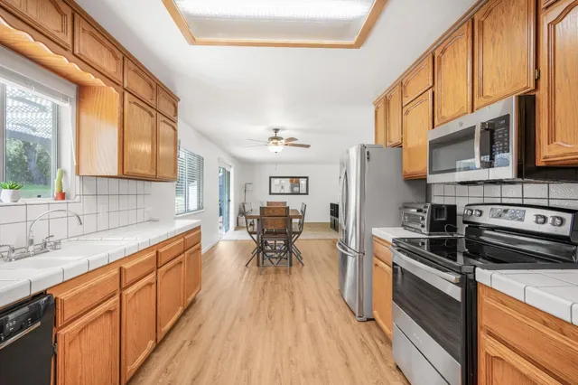 a kitchen with stainless steel appliances kitchen island granite countertop a stove a sink and a refrigerator