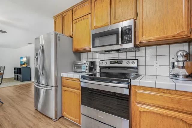 a kitchen with stainless steel appliances granite countertop a refrigerator stove and microwave
