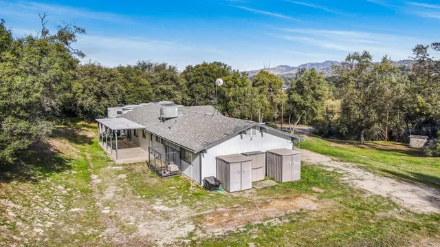 an aerial view of a house with yard and mountain view in back