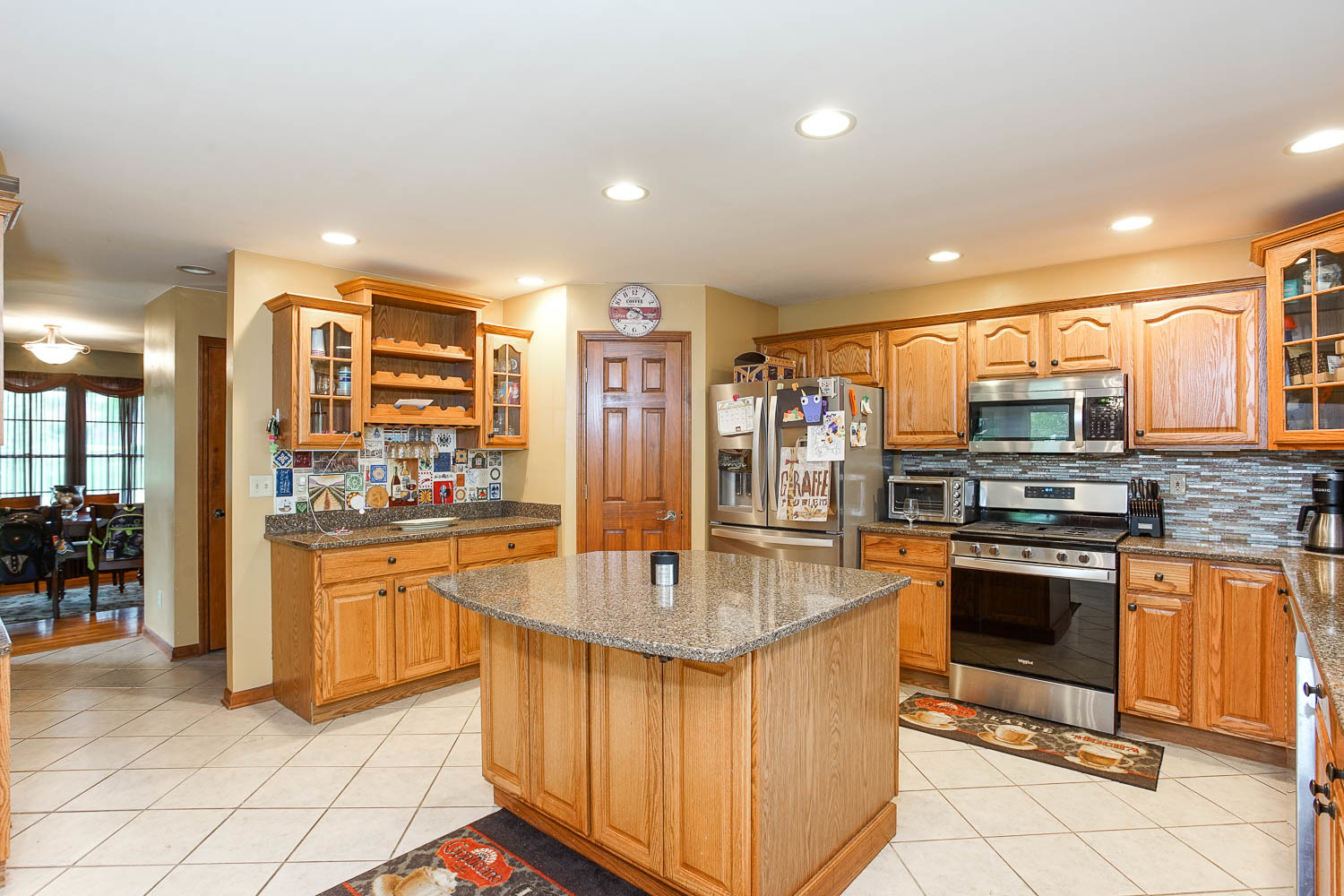 2394 Valley View Drive Kankakee, IL 60901 - Photo 21 of 73 a kitchen with stainless steel appliances granite countertop a stove top oven a sink dishwasher a dining table and chairs with wooden floor