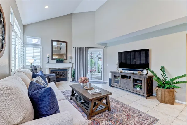 a living room with furniture a flat screen tv and a fireplace