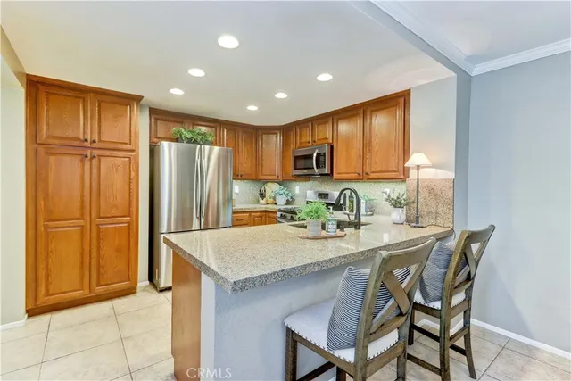 a kitchen with stainless steel appliances granite countertop a refrigerator and a stove top oven