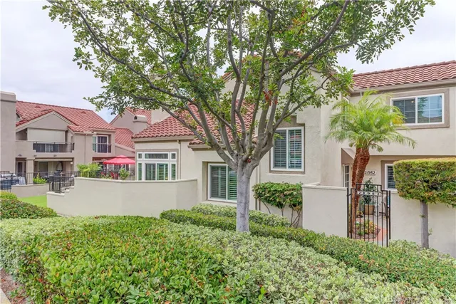 front view of house with a yard and potted plants