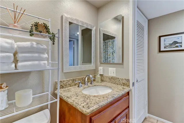 a bathroom with a granite countertop sink and a mirror