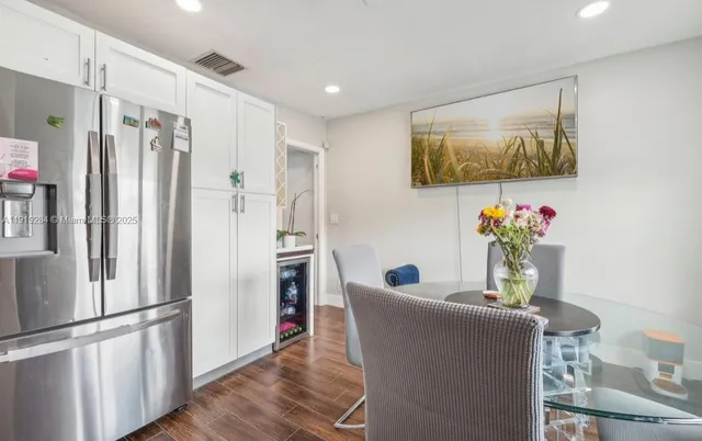 a living room with furniture and a refrigerator