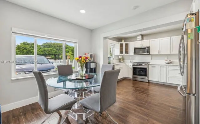a dining room with furniture a window and a kitchen view