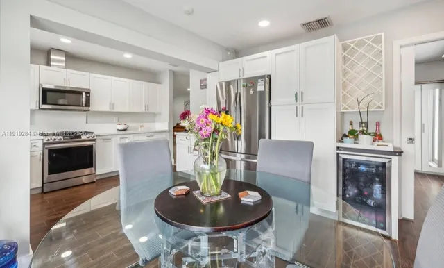 a kitchen with stainless steel appliances kitchen island granite countertop a stove and a dining table with wooden floor