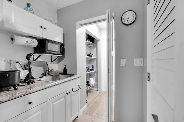 a spacious bathroom with a granite countertop sink and a mirror