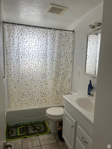 456 500 South Bountiful, UT 84010 - Photo 13 of 19 Full bath with a textured ceiling, vanity, shower / tub combo with curtain, and light tile patterned floors