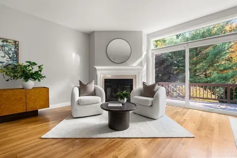 a living room with furniture a fireplace and a large window