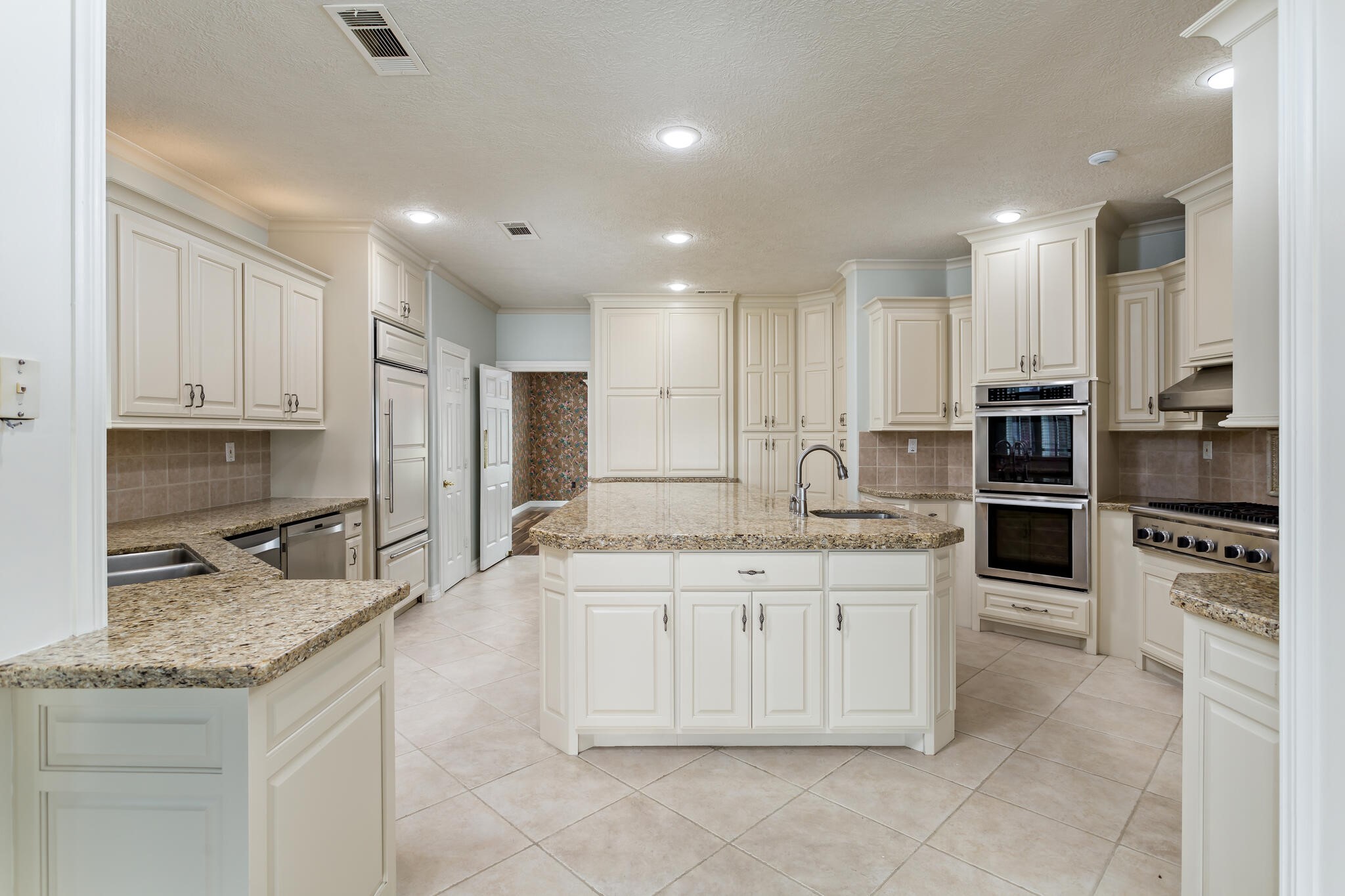 145 Greenhead Point Orange, TX 77630 - Photo 15 of 49 a kitchen with kitchen island granite countertop stainless steel appliances and white cabinets