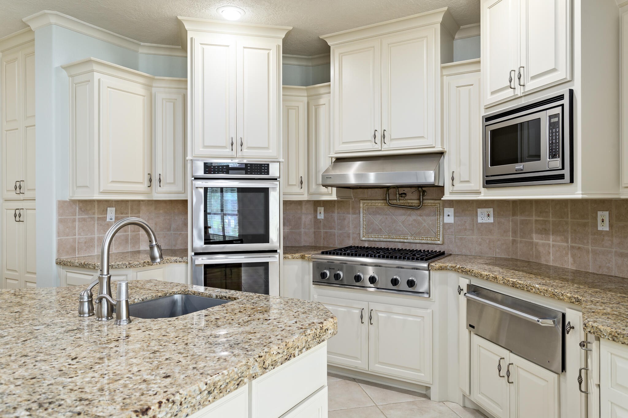 145 Greenhead Point Orange, TX 77630 - Photo 16 of 49 a kitchen with granite countertop white cabinets and stainless steel appliances