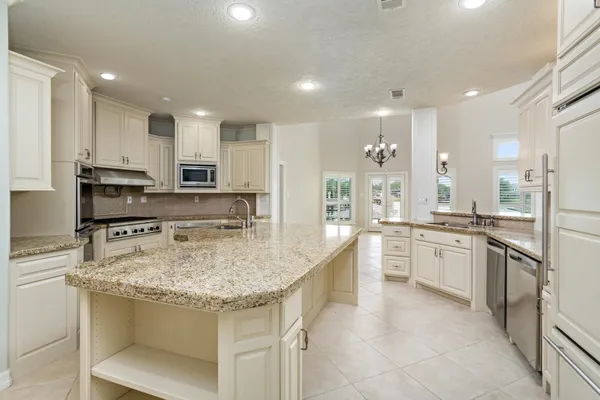 a kitchen with stainless steel appliances granite countertop a sink dishwasher stove top oven and refrigerator