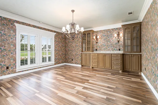 a view of a room with wooden floor windows and a chandelier
