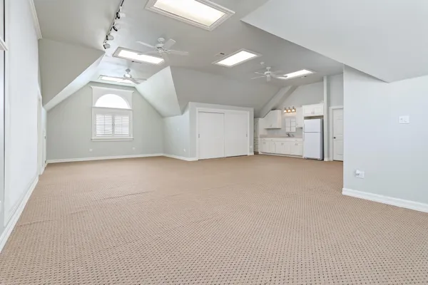 en empty room with windows and ceiling fan
