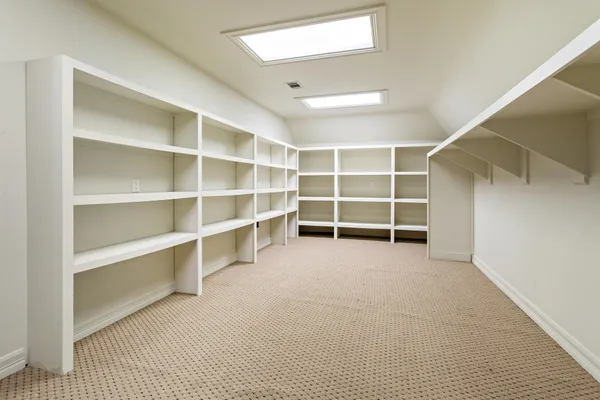 a view of an empty room with a closet and a window