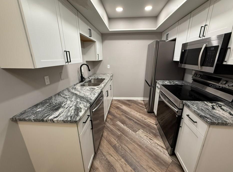 5800 Hollywood Boulevard, Unit 324 Sarasota, FL 34231 - Photo 6 of 11 a kitchen with stainless steel appliances granite countertop a sink stove and refrigerator