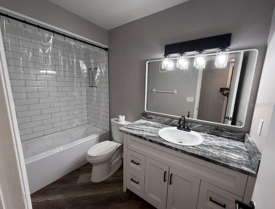 5800 Hollywood Boulevard, Unit 324 Sarasota, FL 34231 - Photo 8 of 11 a bathroom with a granite countertop sink toilet and shower