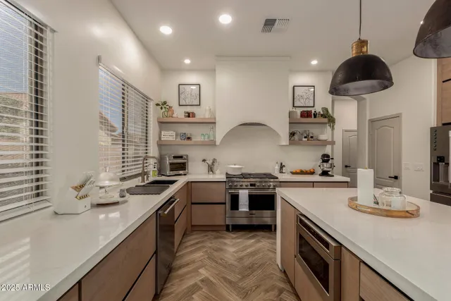 a kitchen with stainless steel appliances a sink a stove and cabinets