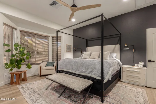 a bedroom with a bed and a large mirror next to a window