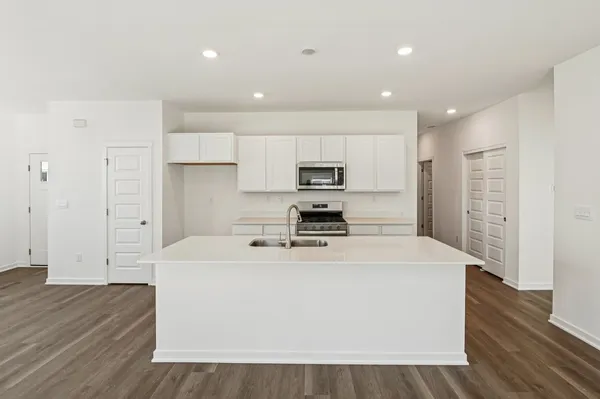 a kitchen with stainless steel appliances a refrigerator sink and microwave