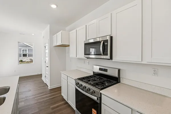 a kitchen with granite countertop a stove and a microwave