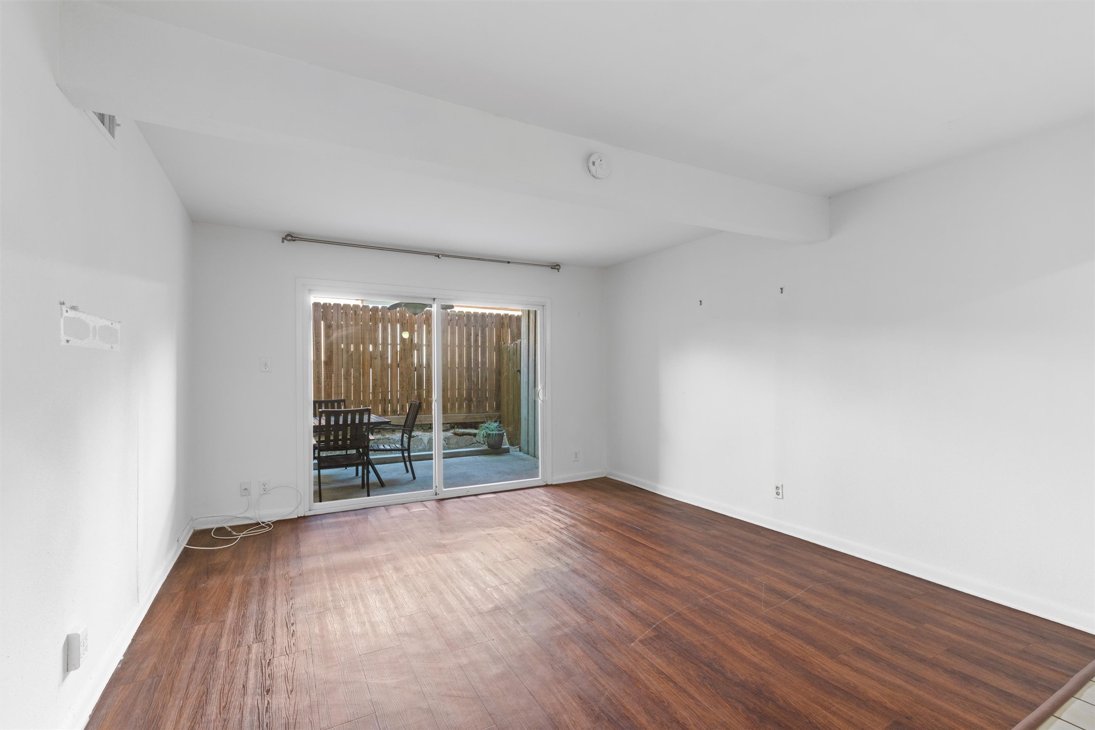 2208 Enfield Road, Unit 10500 Austin, TX 78703 - Photo 11 of 34 Spacious interior featuring wood-finish flooring, white walls, and a recessed ceiling beam