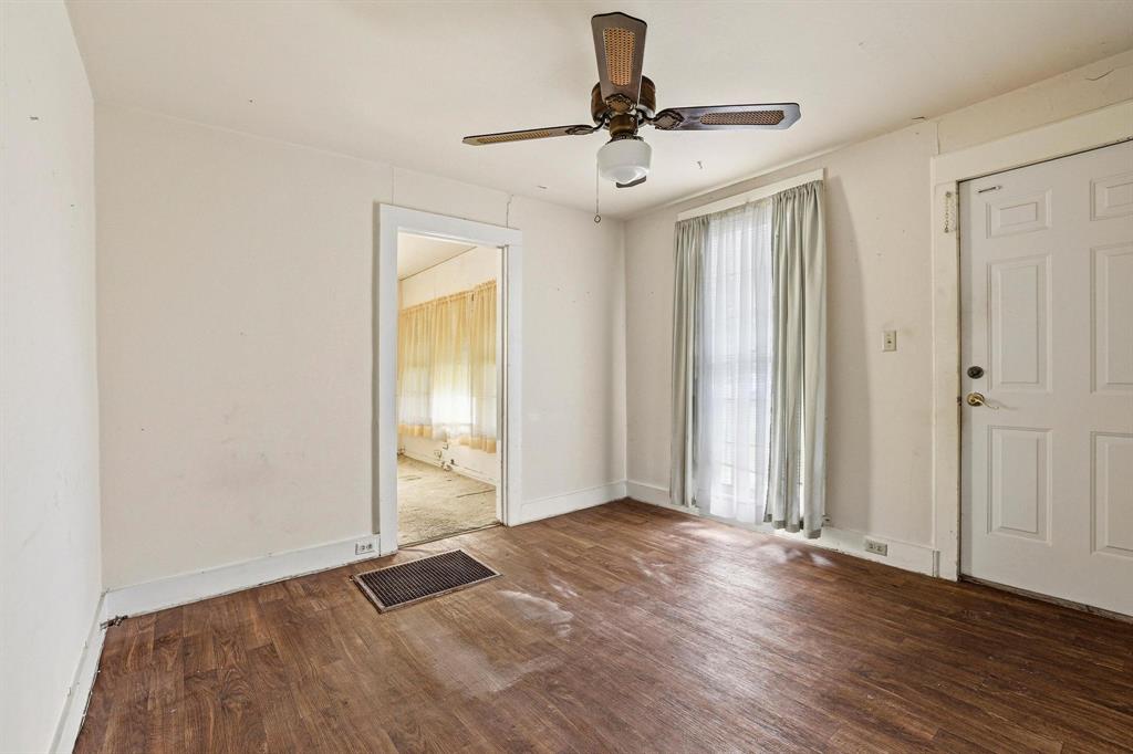 421 East Hull Street Denison, TX 75021 - Photo 10 of 33 an empty room with wooden floor fan and windows