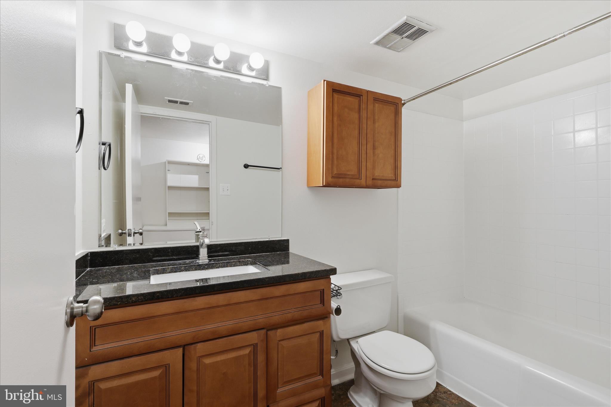 1433 Northgate Square, Unit 11B Reston, VA 20190 - Photo 19 of 44 a bathroom with a sink a toilet a mirror and shower