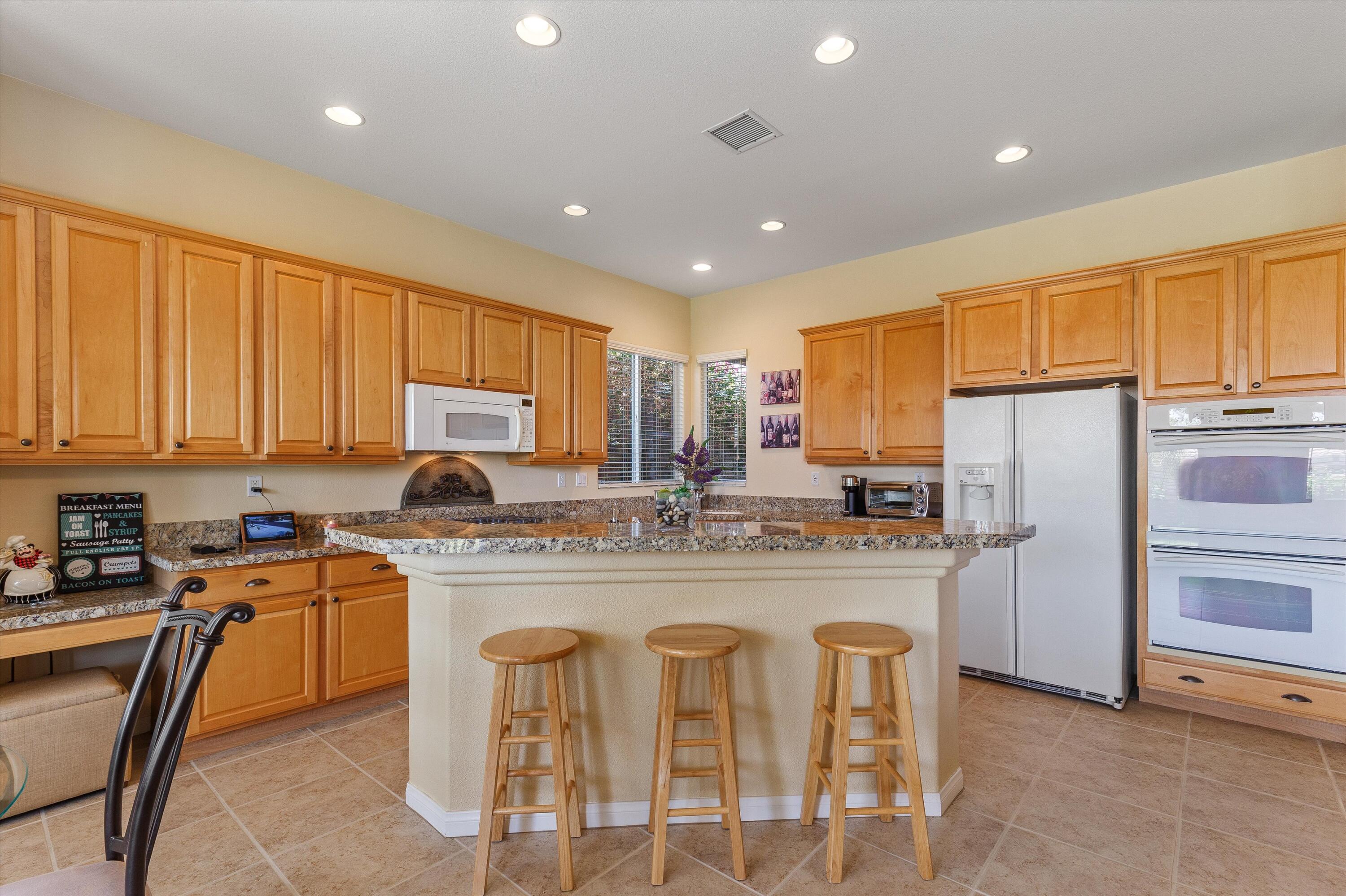 27 Via Del Maricale Rancho Mirage, CA 92270 - Photo 5 of 52 a kitchen with refrigerator a stove a sink and chairs
