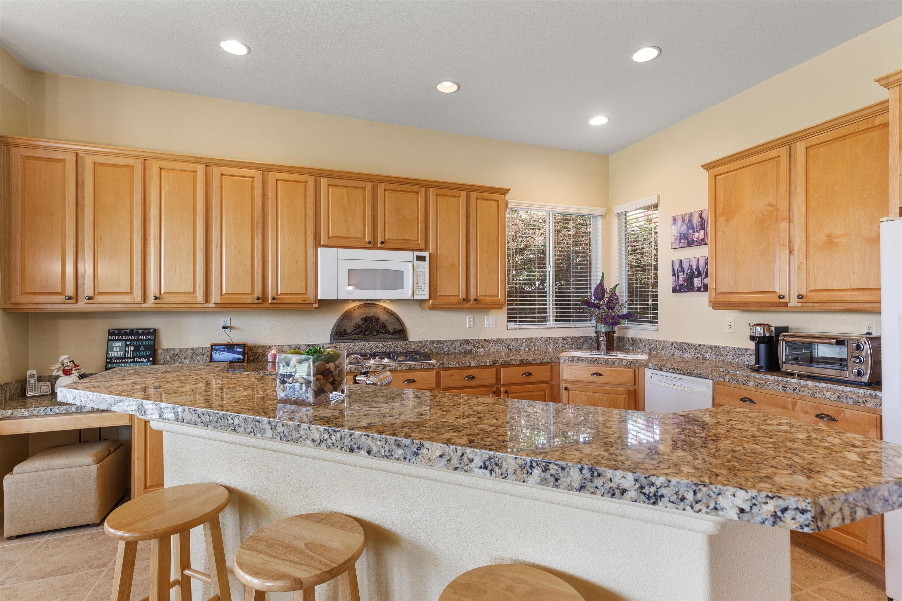 27 Via Del Maricale Rancho Mirage, CA 92270 - Photo 6 of 52 a kitchen with granite countertop lots of counter top space a sink a stove a dining table and chairs