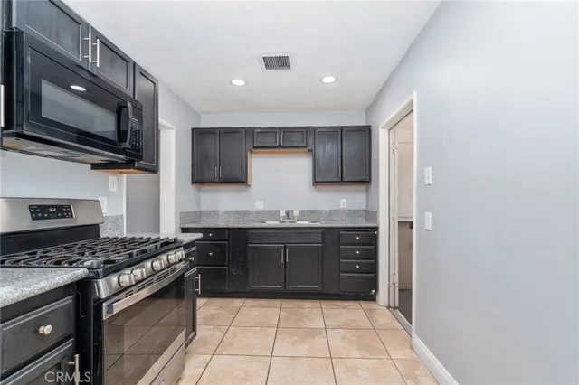 a kitchen with stainless steel appliances granite countertop a stove top oven microwave and cabinets