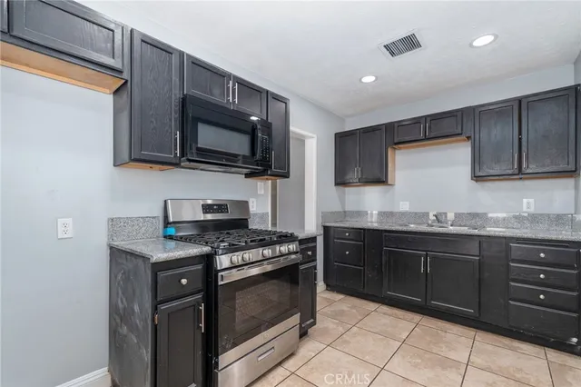 a kitchen with granite countertop wooden cabinets and a stove top oven