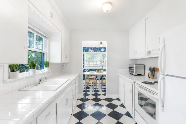 a kitchen with a sink a stove a refrigerator and cabinets