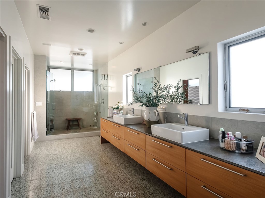 121 16th Street Manhattan Beach, CA 90266 - Photo 20 of 39 a bathroom with double vanity sinks a large mirror and a shower